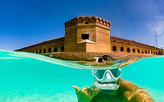 underwater photo of a man snorkeing, smiling at the camera