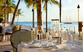 close up image of high class cutlery and drinkwhare on a white cloth draped table