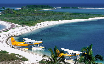 boat plane flying onto the beach, slightly landing on water